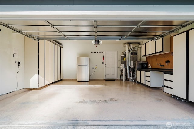 garage with a garage door opener and freestanding refrigerator