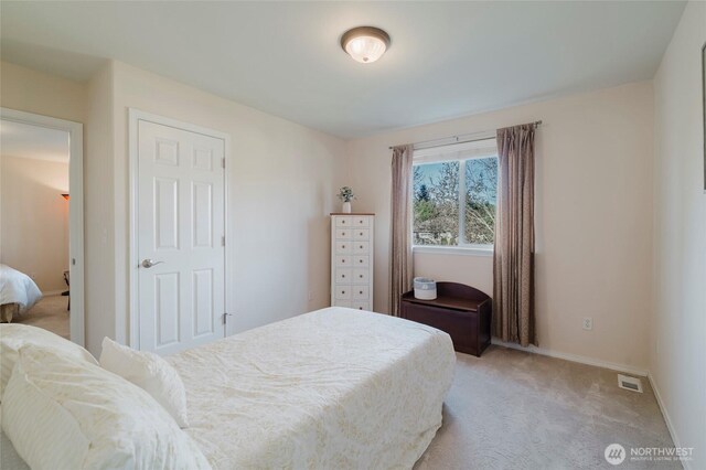 bedroom with visible vents, baseboards, and light carpet