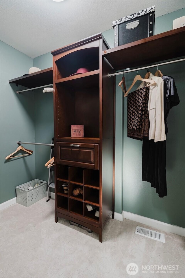 walk in closet with visible vents and carpet flooring