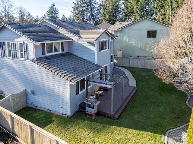 back of house with a fenced backyard, crawl space, a deck, a tiled roof, and a lawn