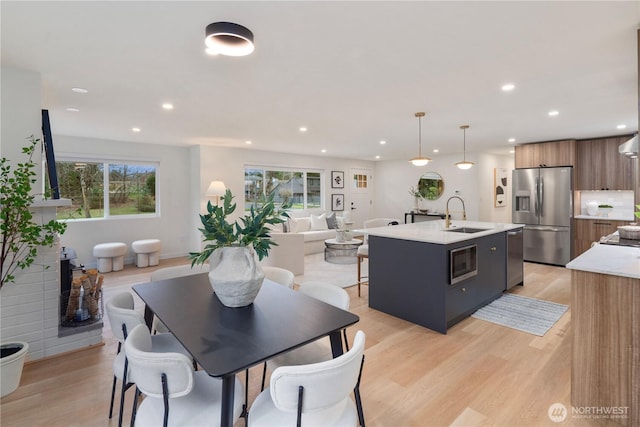 dining area featuring light wood finished floors, recessed lighting, and a wealth of natural light