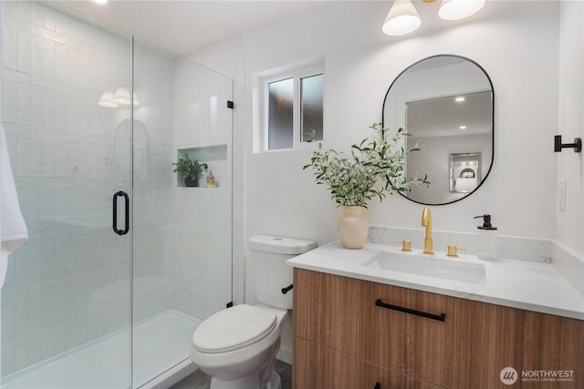 bathroom with a stall shower, toilet, and vanity