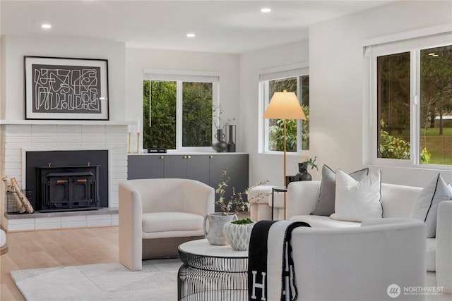 living area with a fireplace, recessed lighting, and wood finished floors