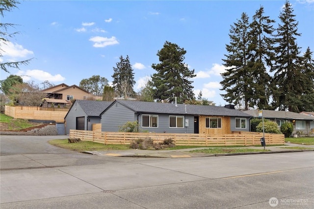 ranch-style home with a garage, a fenced front yard, and a chimney