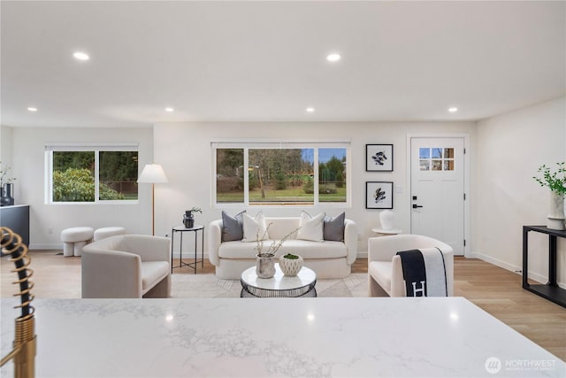 living room with recessed lighting, light wood-type flooring, and baseboards