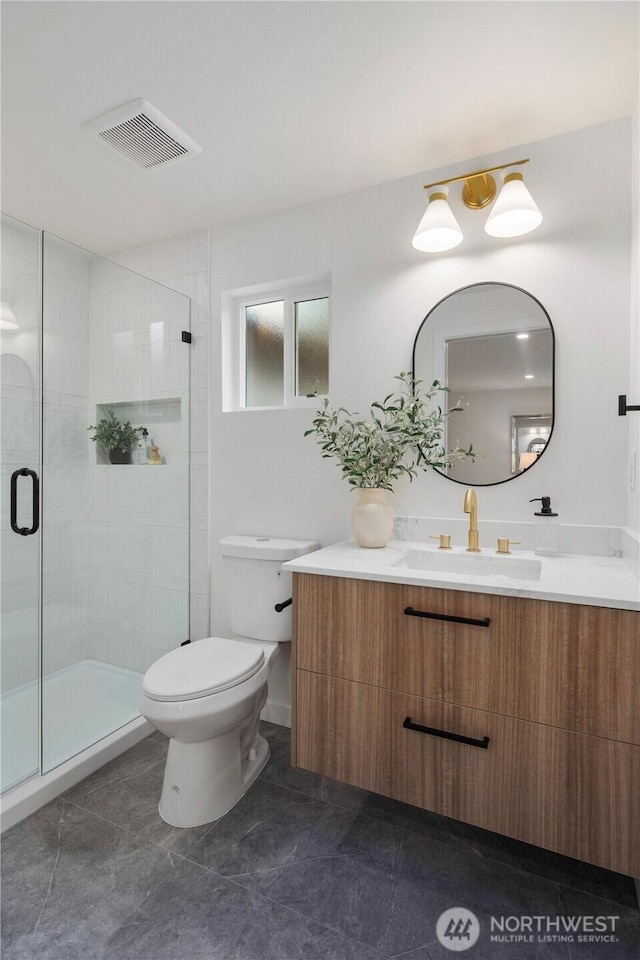 bathroom with vanity, toilet, visible vents, and a stall shower