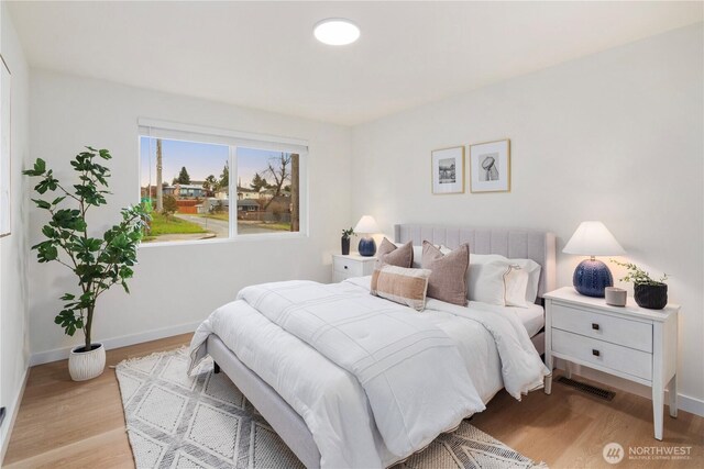 bedroom featuring visible vents, baseboards, and light wood-style floors