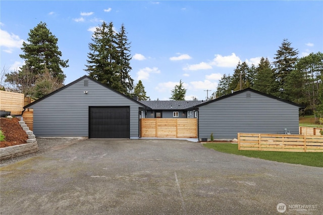 exterior space featuring aphalt driveway, a gate, and fence