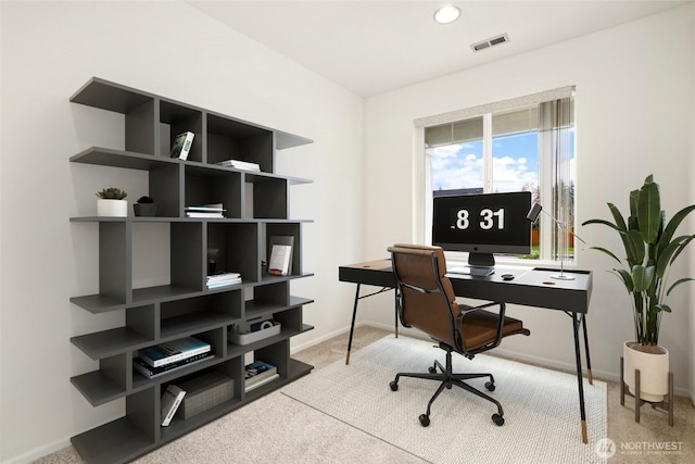 office with visible vents, baseboards, and light colored carpet