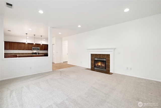 unfurnished living room featuring recessed lighting, visible vents, and light colored carpet