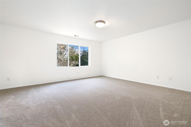 carpeted spare room featuring visible vents and baseboards