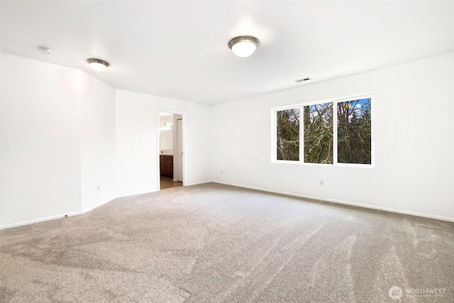 carpeted spare room featuring visible vents and baseboards