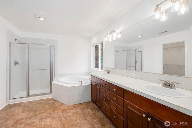 bathroom with a shower stall, a bath, visible vents, and a sink