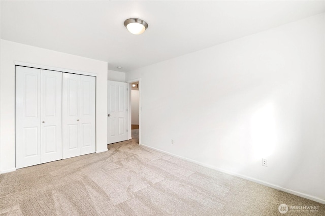 unfurnished bedroom with a closet, baseboards, and carpet