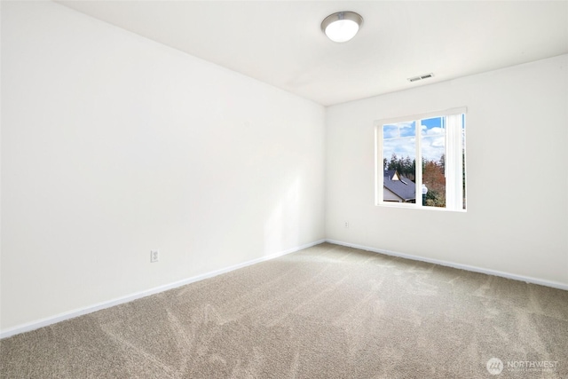 carpeted spare room featuring baseboards and visible vents