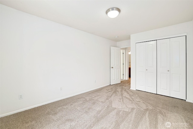 unfurnished bedroom with a closet, baseboards, and carpet