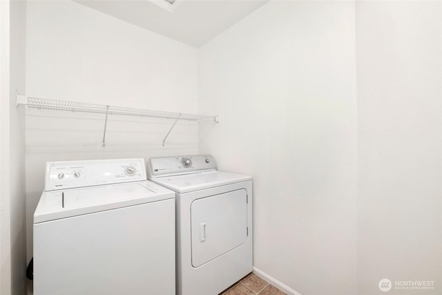 laundry room with baseboards, separate washer and dryer, and laundry area