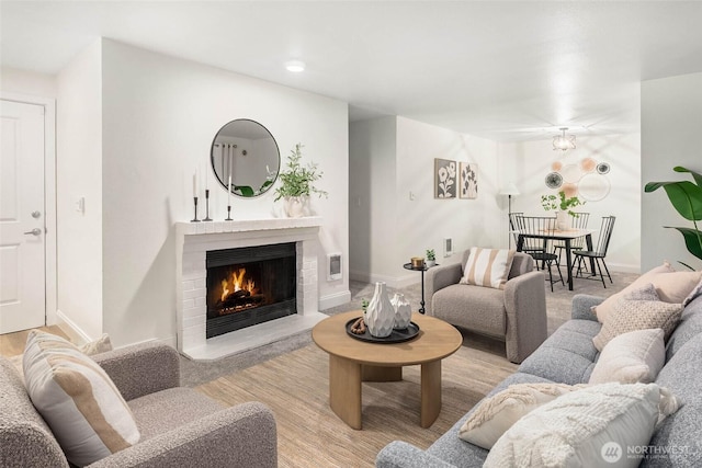 living area with visible vents, baseboards, and a brick fireplace