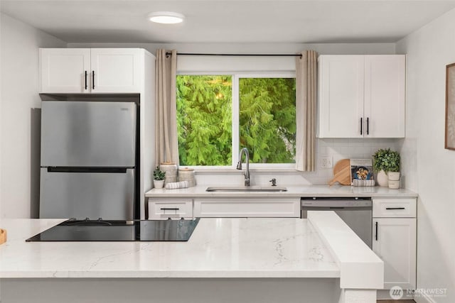 kitchen featuring a sink, white cabinets, a wealth of natural light, and stainless steel appliances