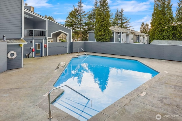 view of swimming pool featuring a fenced in pool, a patio, and fence