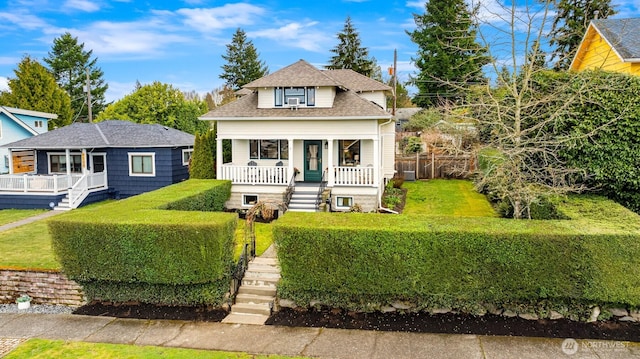 bungalow with fence, stairway, covered porch, a front yard, and a shingled roof