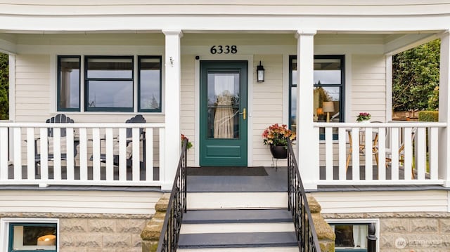 view of exterior entry featuring covered porch