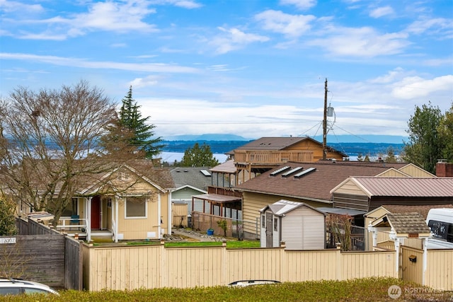 view of front facade with a mountain view, fence private yard, and an outdoor structure