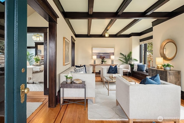 living room with beamed ceiling and wood finished floors