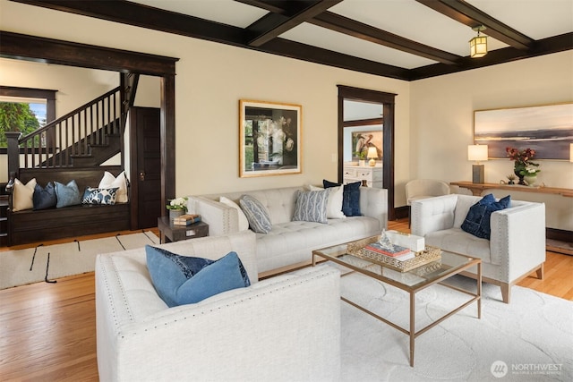 living room featuring stairway, wood finished floors, beamed ceiling, and baseboards