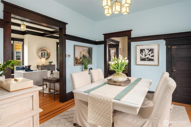 dining space featuring light wood finished floors and a chandelier