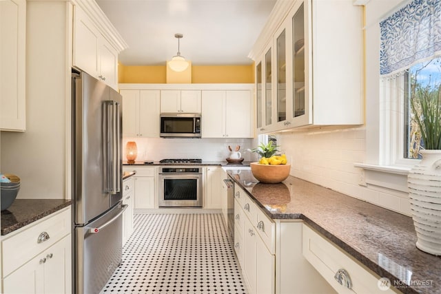 kitchen featuring backsplash, stainless steel appliances, glass insert cabinets, and dark stone counters