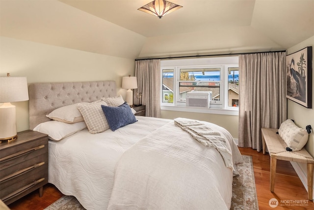 bedroom with lofted ceiling and wood finished floors