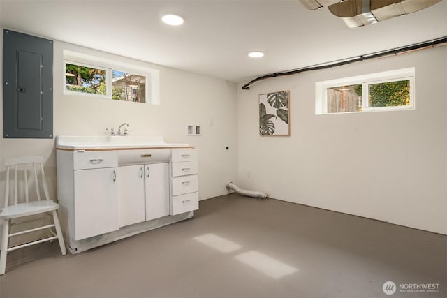 interior space featuring electric panel, recessed lighting, and a sink