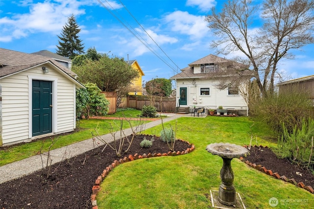 view of yard with entry steps, an outbuilding, and fence