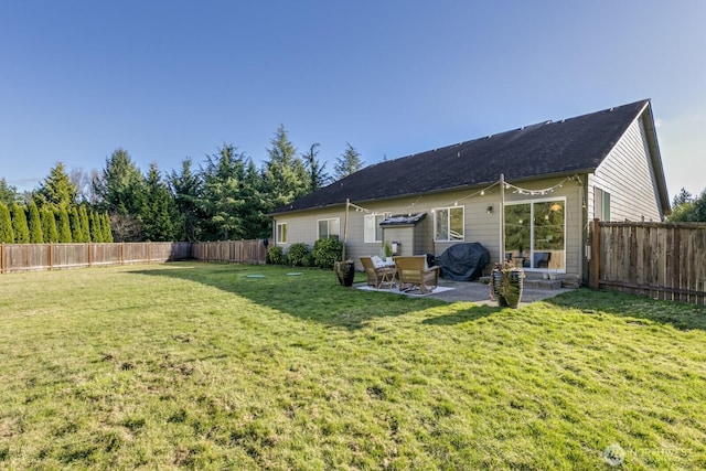 rear view of house featuring a patio area, a yard, and a fenced backyard