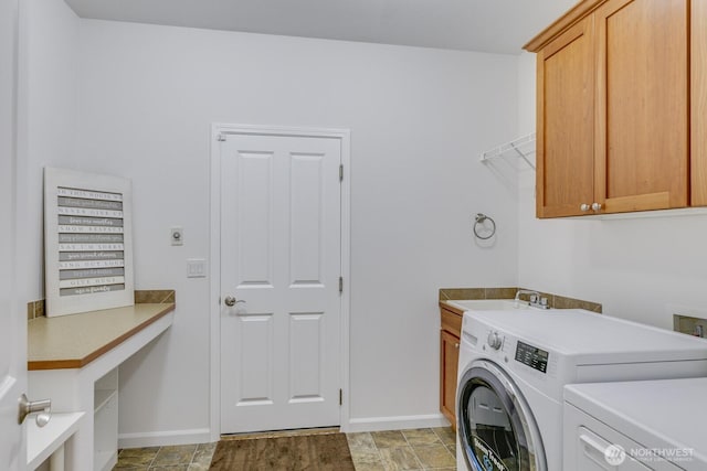 laundry area featuring a sink, baseboards, cabinet space, and independent washer and dryer