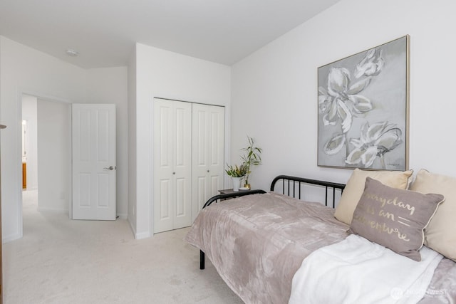 carpeted bedroom with a closet and baseboards