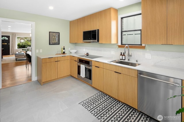 kitchen with decorative backsplash, appliances with stainless steel finishes, light countertops, and a sink