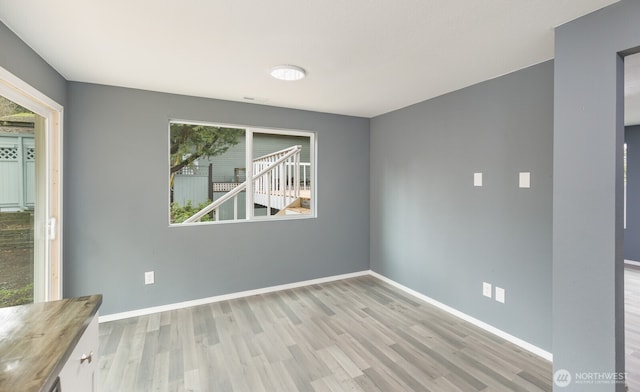 empty room with baseboards and wood finished floors