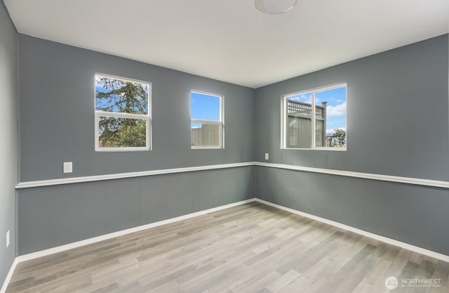 empty room with wood finished floors and baseboards