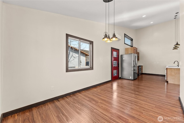 interior space featuring a sink, baseboards, and wood finished floors