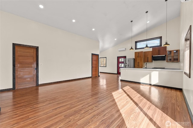 unfurnished living room with high vaulted ceiling, light wood-style flooring, a sink, recessed lighting, and baseboards