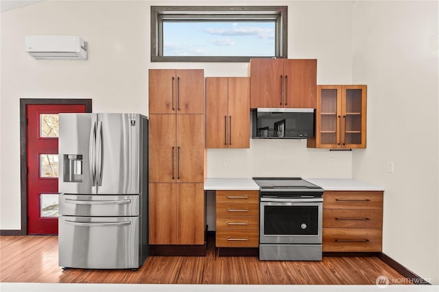 kitchen featuring a wall mounted air conditioner, brown cabinets, and appliances with stainless steel finishes