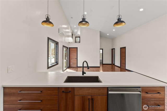 kitchen with brown cabinets, dishwasher, light countertops, and a sink