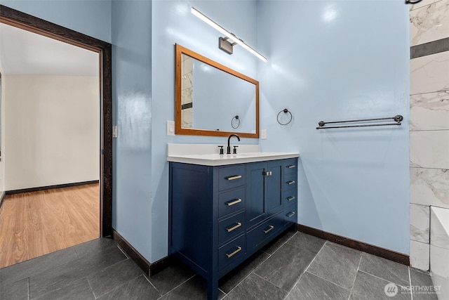 bathroom featuring vanity, wood finished floors, and baseboards