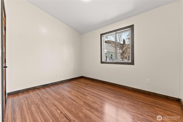 empty room with baseboards and wood finished floors