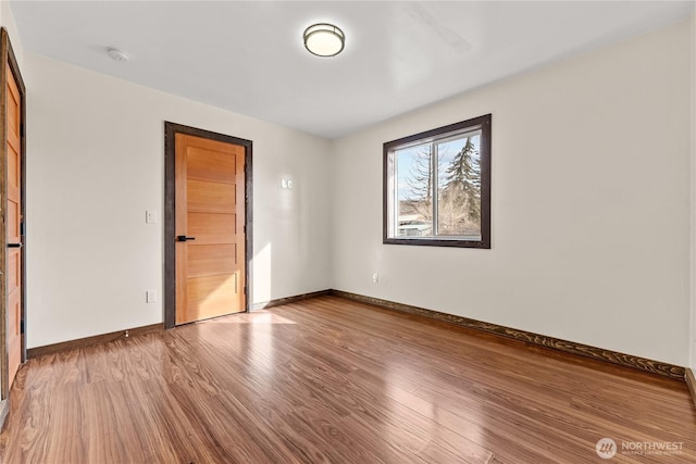 empty room featuring baseboards and wood finished floors