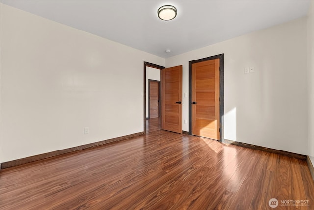 unfurnished bedroom featuring wood finished floors and baseboards