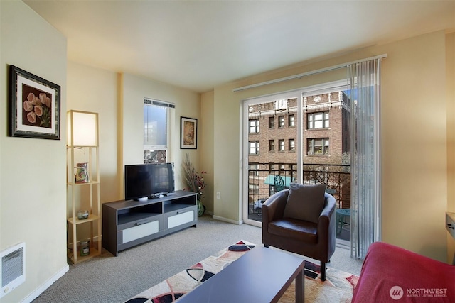 living area with visible vents, plenty of natural light, baseboards, and carpet flooring