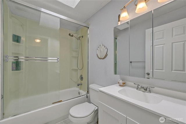 bathroom featuring toilet, vanity, and shower / bath combination with glass door